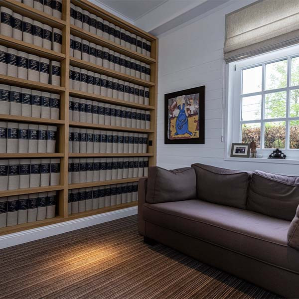 Photo d'une salle avec etagere à livres avec un tableau representant un lapin bleu et un canapé.